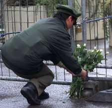 German policeman placing flowers in memory
	of the September 11 victims in front of the 
	U.S. Embassy